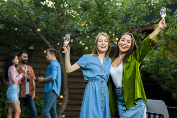 Front view happy young girls raising glasses