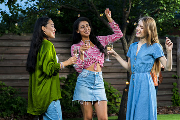 Group of girls dancing together with drinks