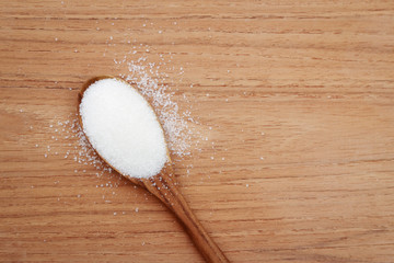 sugar on wooden spoon background for create food content 