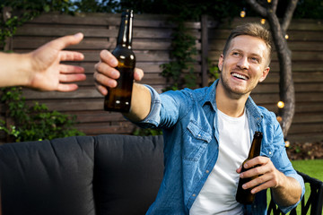 Cheerful young man passing a beer