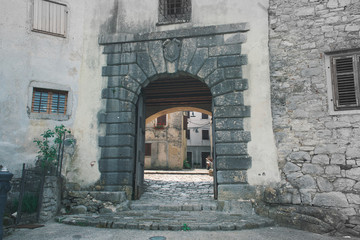 The town center with traditional historic houses, medieval arch and old pavement in the small Istrian city Buzet, Croatia