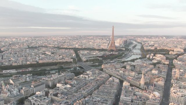 Aerial shot of the Skyline of Paris. France with the Eiffel Tower being lit by the sunset