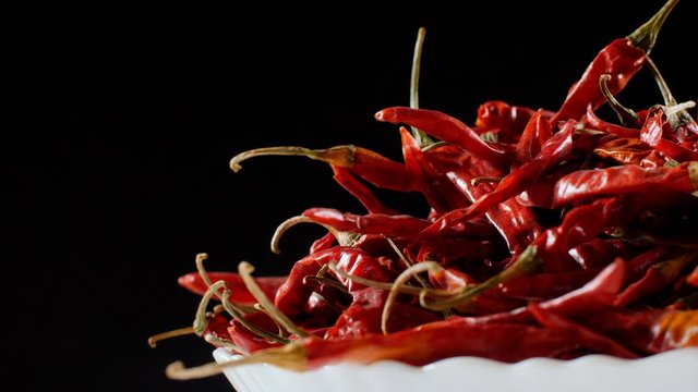 Rotating heap of dried red chilies (Indian Masala - Lal Mirch) in a bowl . 