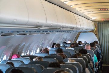 Blurred photo of the aircraft interior. Passengers in the cabin airplane
