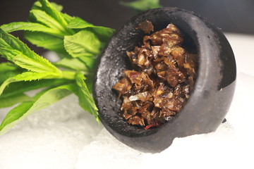 bowl with tobacco for hookah. berries on a black background