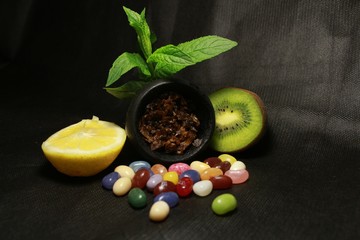 bowl with tobacco for hookah. berries on a black background