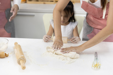 Obraz na płótnie Canvas Asian Women thresh flour with daughter for making bakery in the kitchen in home. family cooking food Concept.