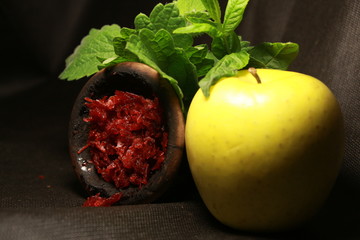 bowl with tobacco for hookah. berries on a black background