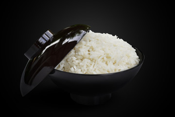 Jasmine cooked rice in a black bowl isolated on the black background. This has clipping path.