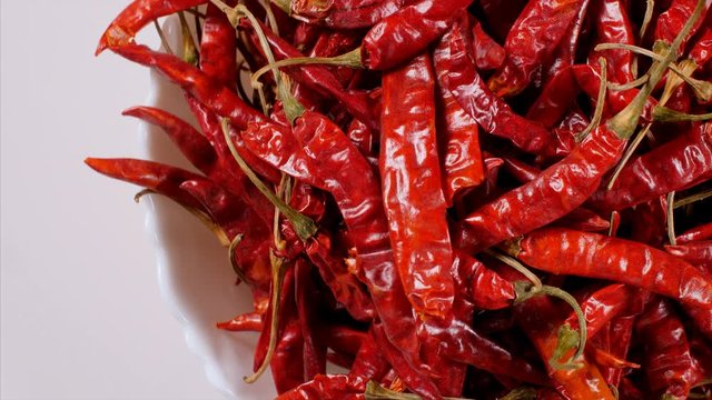 Top view of rotating dry red pepper - Lal Mirch kept in bowl. 