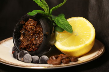 bowl with tobacco for hookah. berries on a black background