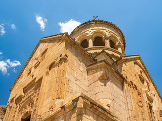 Facade of Surb Astvatsatsin church, also called Burtelashen, in Noravank Monastery, Armenia, against blue summer sky.