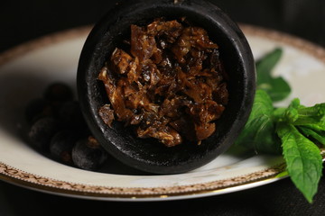 bowl with tobacco for hookah. berries on a black background
