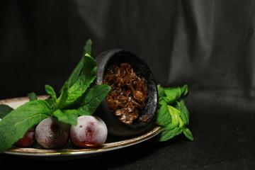 bowl with tobacco for hookah. berries on a black background
