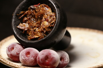 bowl with tobacco for hookah. berries on a black background