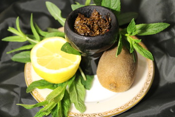 bowl with tobacco for hookah. berries on a black background