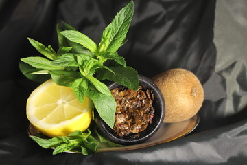 bowl with tobacco for hookah. berries on a black background