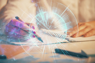 International business hologram over hands taking notes background. Concept of success. Multi exposure