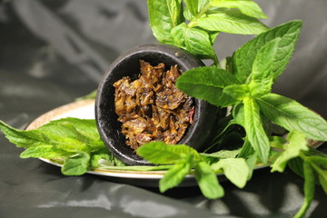 bowl with tobacco for hookah. fruits on a black background. smoking hookah