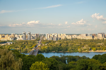 View of the city of Kiev, the Dnieper River. City panorama with a place across the river, park, summer day.