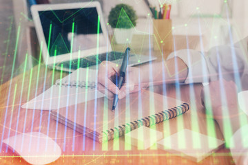 Financial charts displayed on woman's hand taking notes background. Concept of research. Double...