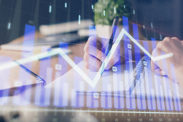 Financial forex graph drawn over hands taking notes background. Concept of research. Multi exposure