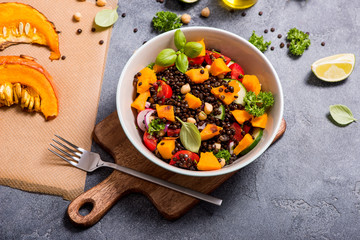 Healthy salad with roasted squash, chickpeas and black lentils, autumn food, vegan eating