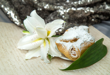 Fototapeta na wymiar white lush beautiful lily with fresh pastries on a retro background