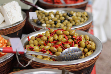 A basket of olives with chilli peppers on a Mediterranean market