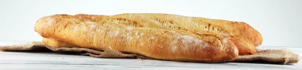 Assortment of baked bread and bread rolls on white table background