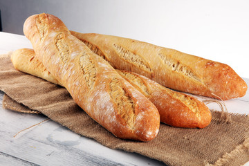 Assortment of baked bread and bread rolls on white table background