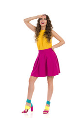 Surprised Young Woman In Colorful High Heels And Pink Mini Skirt Is Looking Up