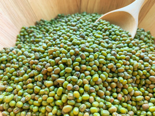 Many mungbean or green beans in wooden bowls and wooden spoons for scoop