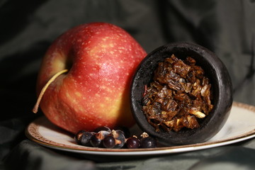 bowl with tobacco for hookah. berries on a black background