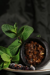 bowl with tobacco for hookah. berries on a black background