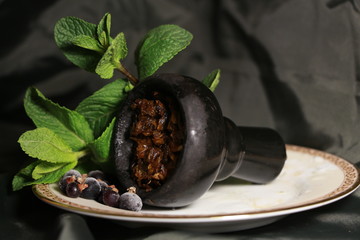 bowl with tobacco for hookah. berries on a black background