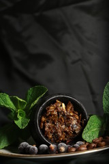 bowl with tobacco for hookah. berries on a black background