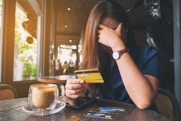 Closeup image of an Asian woman get stressed and broke while holding credit card