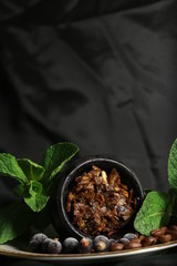 bowl with tobacco for hookah. berries on a black background