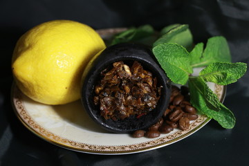bowl with tobacco for hookah. berries on a black background