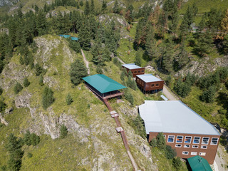 A landscape with a picturesque place in the mountains at the top of the cliff stands a gazebo with...