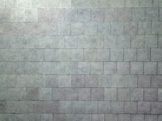 Background from texture of equal square rough gray plates. Decoration and design.
