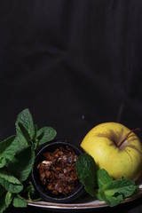 bowl with tobacco for hookah. fruits on a dark background. smoking hooka