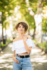 Young woman wearing straw hat while walking in green park