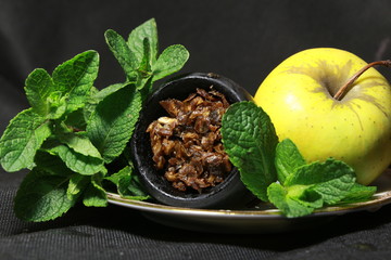 bowl with tobacco for hookah. berries on a black background
