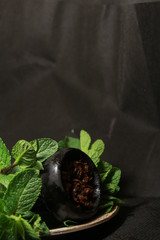 bowl with tobacco for hookah. fruits on a black background. smoking hookah
