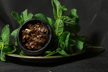 bowl with tobacco for hookah. berries on a black background