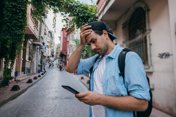 A man is looking for a way in the navigator on the phone while traveling