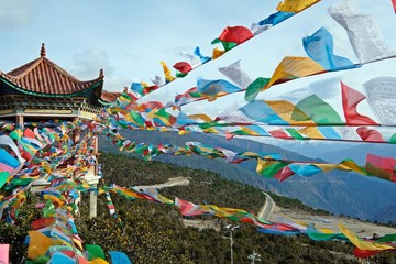 Plenty of 5-color prayer flags in which each flag contains prayer swaying by the wind showing...