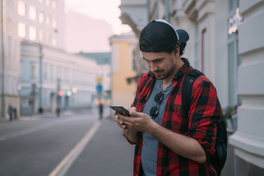 A Man Is Looking For A Way In The Navigator On The Phone While Traveling